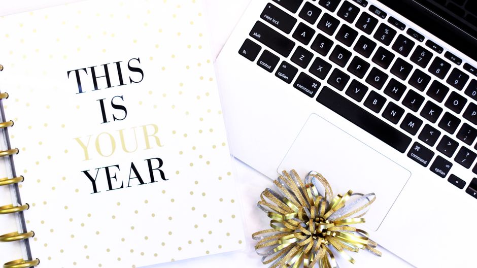 A stylish desk setup featuring a laptop and a motivational notebook for productivity inspiration.
